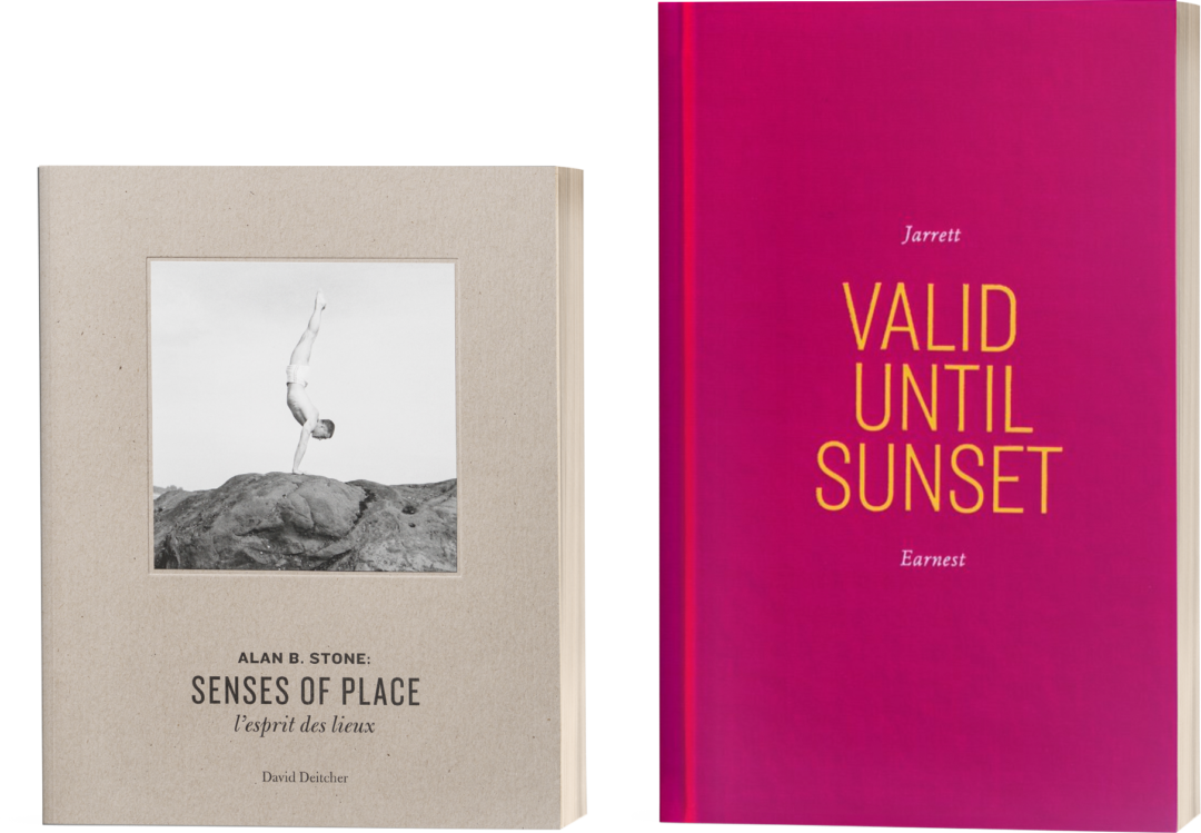 Two books side by side. The beige book on the left has a black and white photo of a man doing a handstand and is titled Alan B. Stone: Senses of Place; l’esprit des lieux and Valid Until Sunset. The book on the right is a shocking magenta color and is titled Valid Until Sunset